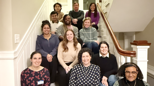 A group of graduate students and administrators sitting on a staircase.
