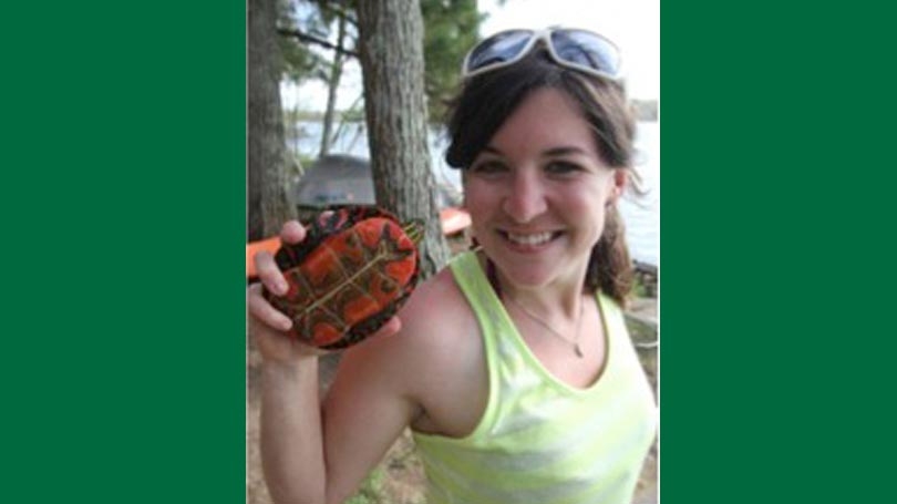 Beth Reinke holds a snapping turutle showing the caretenoids coloring on the underside