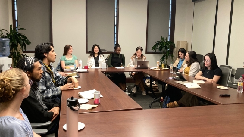 Graduate students seated around a conference table