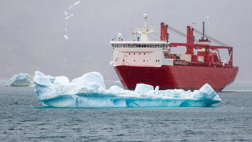 a container ship at sea near icebergs in the harbor of Narsaq, Southern Greenland