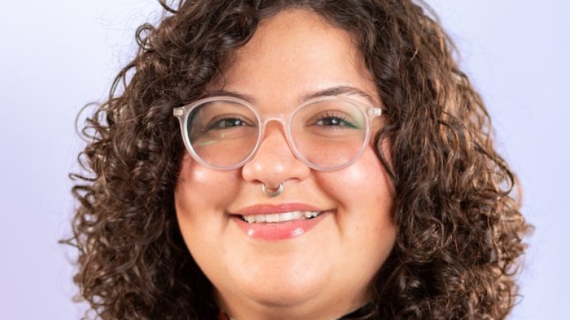 A woman with glasses smiling at the camera