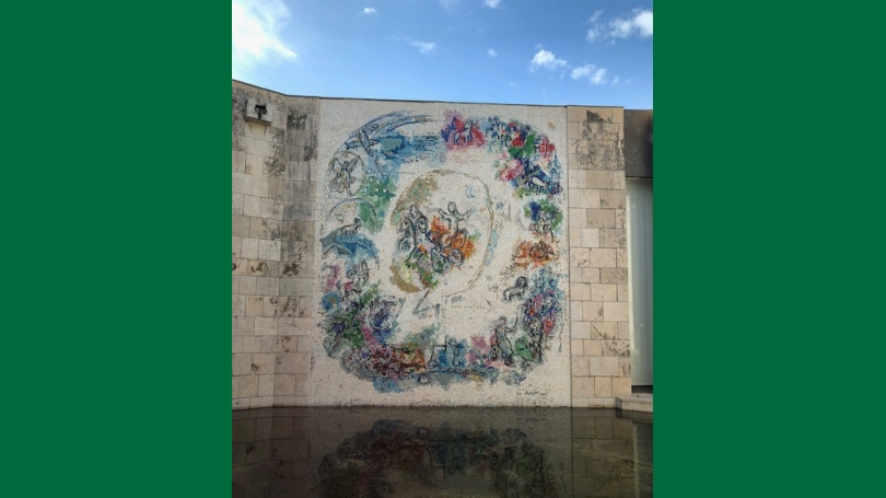 A mural of animals and symbols drawn on a concrete wall.