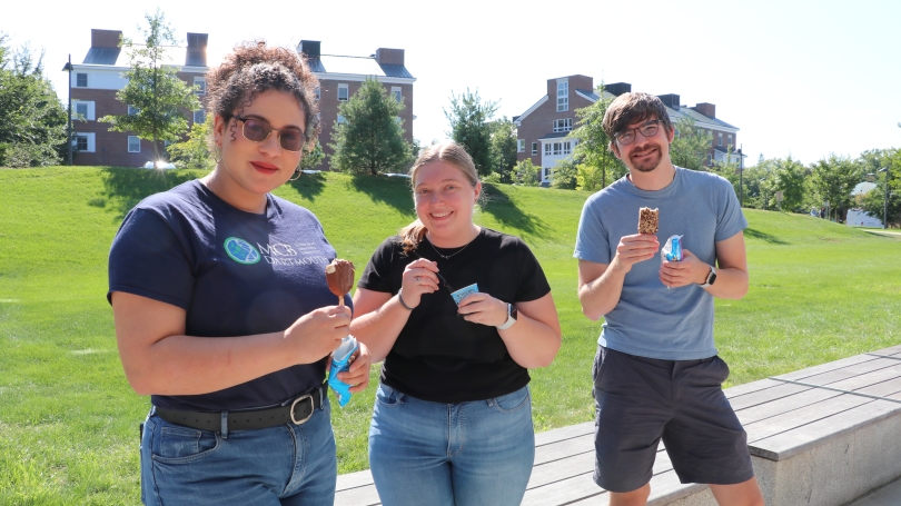 Graduate students smiling and holding ice cream
