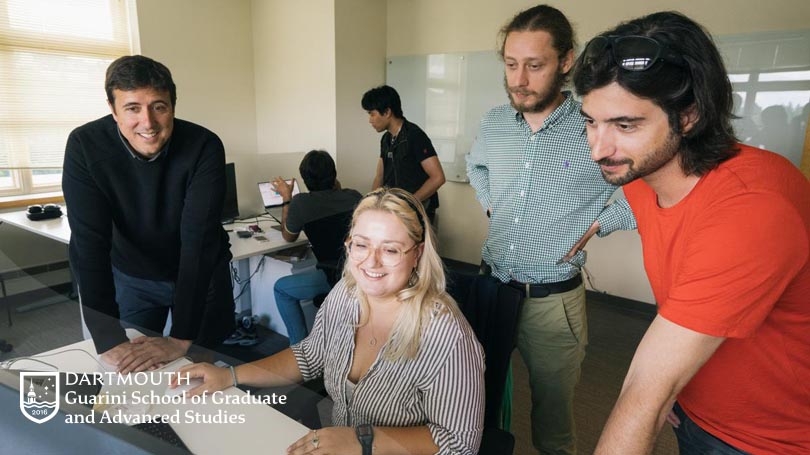 From left, standing, Professor Tor Wager, research assistant Léo Henry, and graduate student Bogdan Petre, Guarini '24, look over a data analysis project by research assistant Melanie Kos '20, seated. (Photo by Eli Burakian '00)