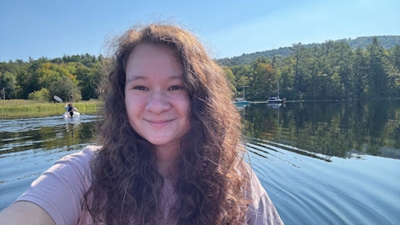 woman in a kayak paddling on a lake.