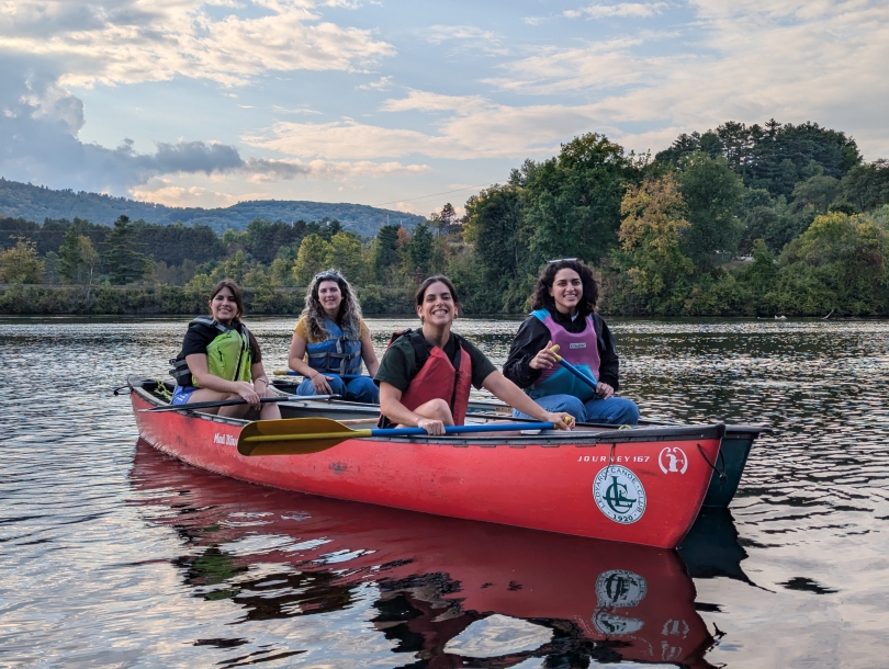 Four women in a canoe paddling.